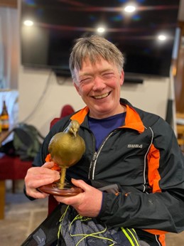 Man with golden pigeon trophy